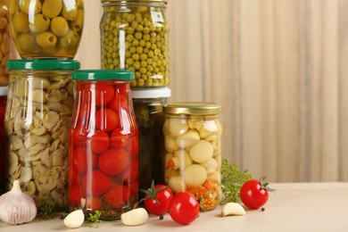 Jars of pickled vegetables on wooden table