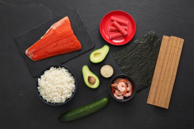 Photo of Flat lay composition with ingredients for sushi on dark textured table
