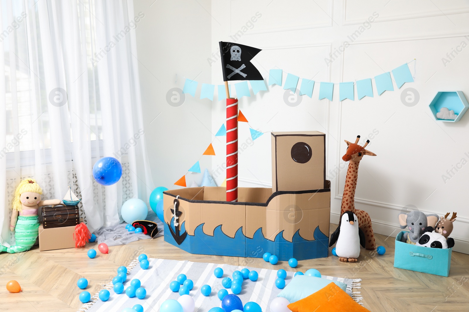 Photo of Child's room interior with pirate cardboard ship and toys