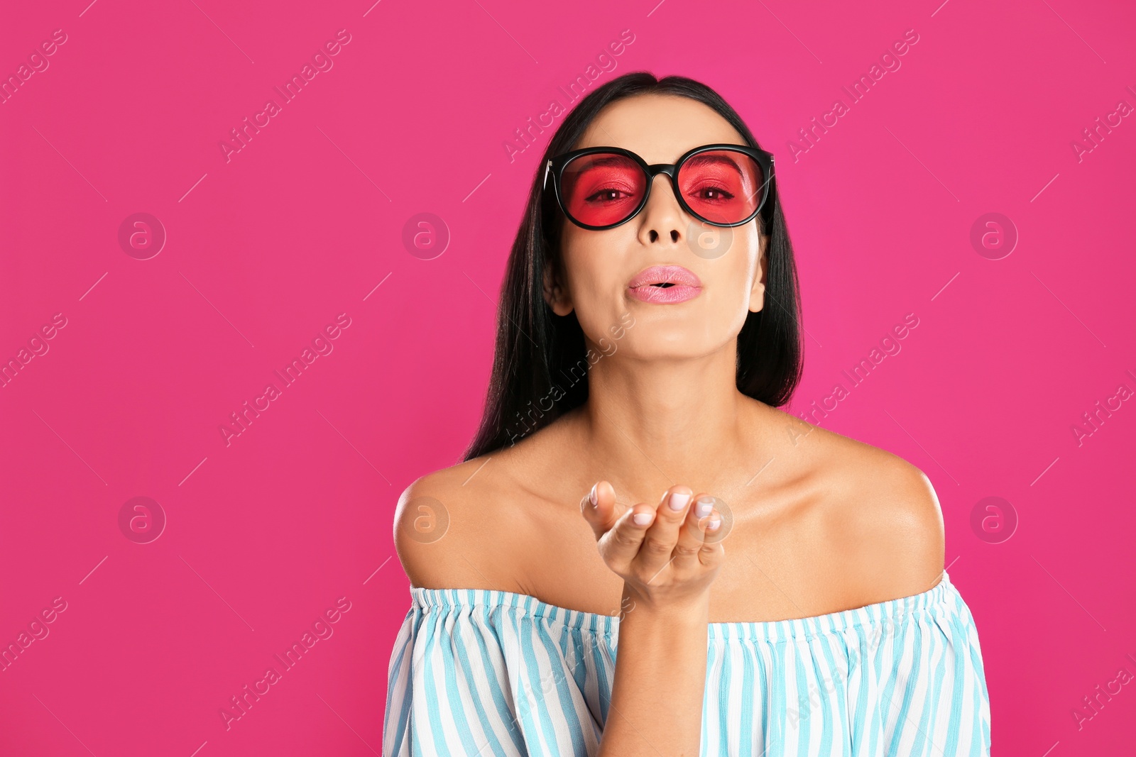 Photo of Beautiful woman wearing sunglasses on pink background