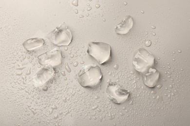 Photo of Pieces of crushed ice on grey background, top view