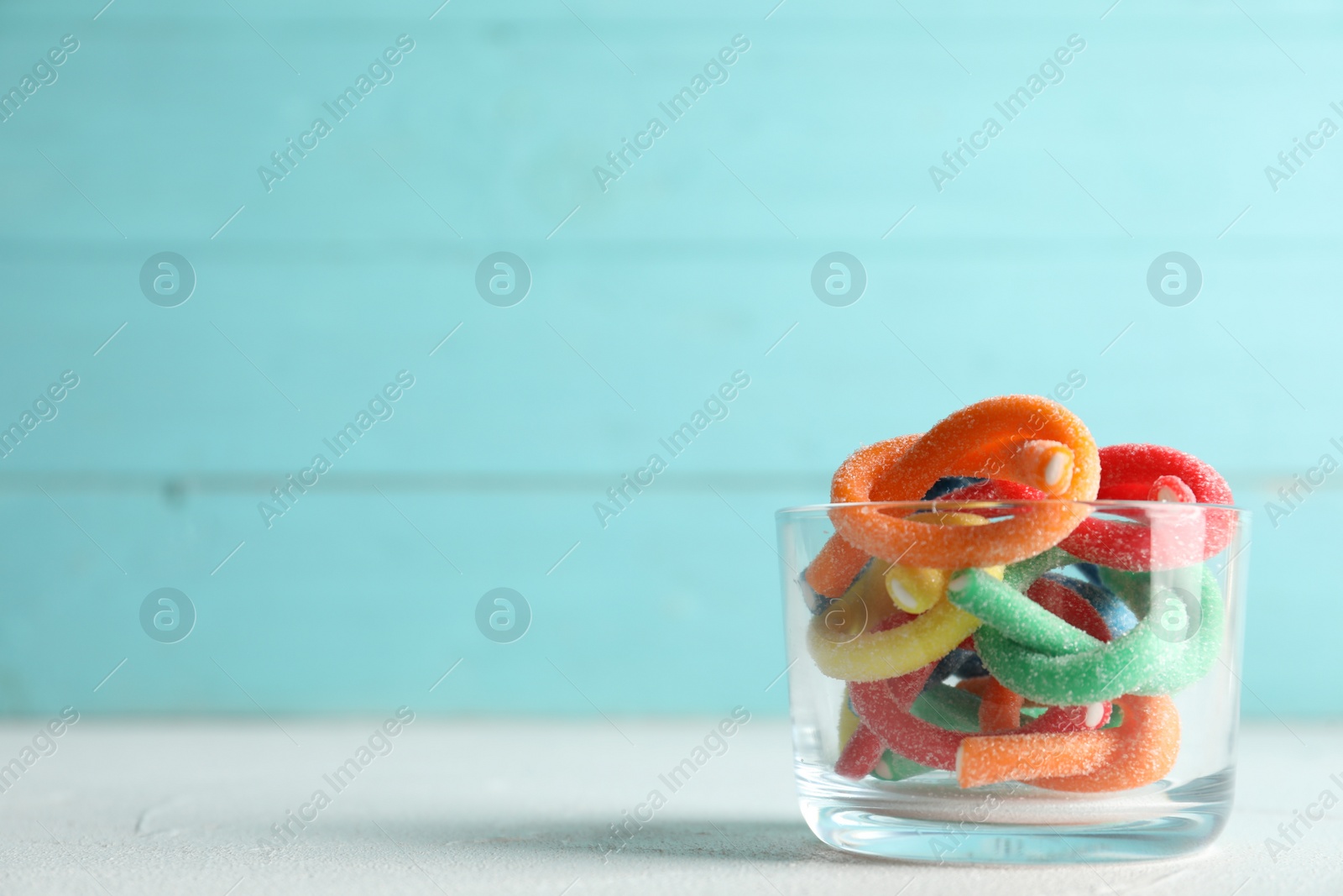 Photo of Delicious bright candies on white table. Space for text