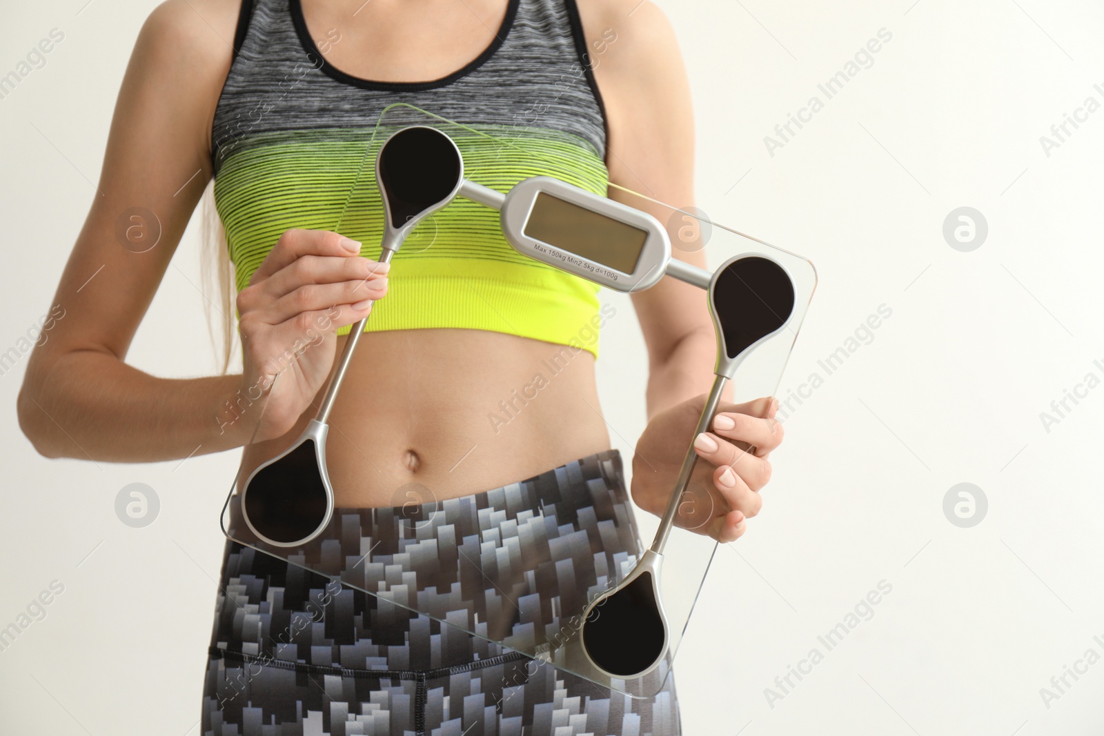 Photo of Woman holding scales on light background. Healthy diet