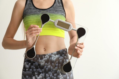 Photo of Woman holding scales on light background. Healthy diet