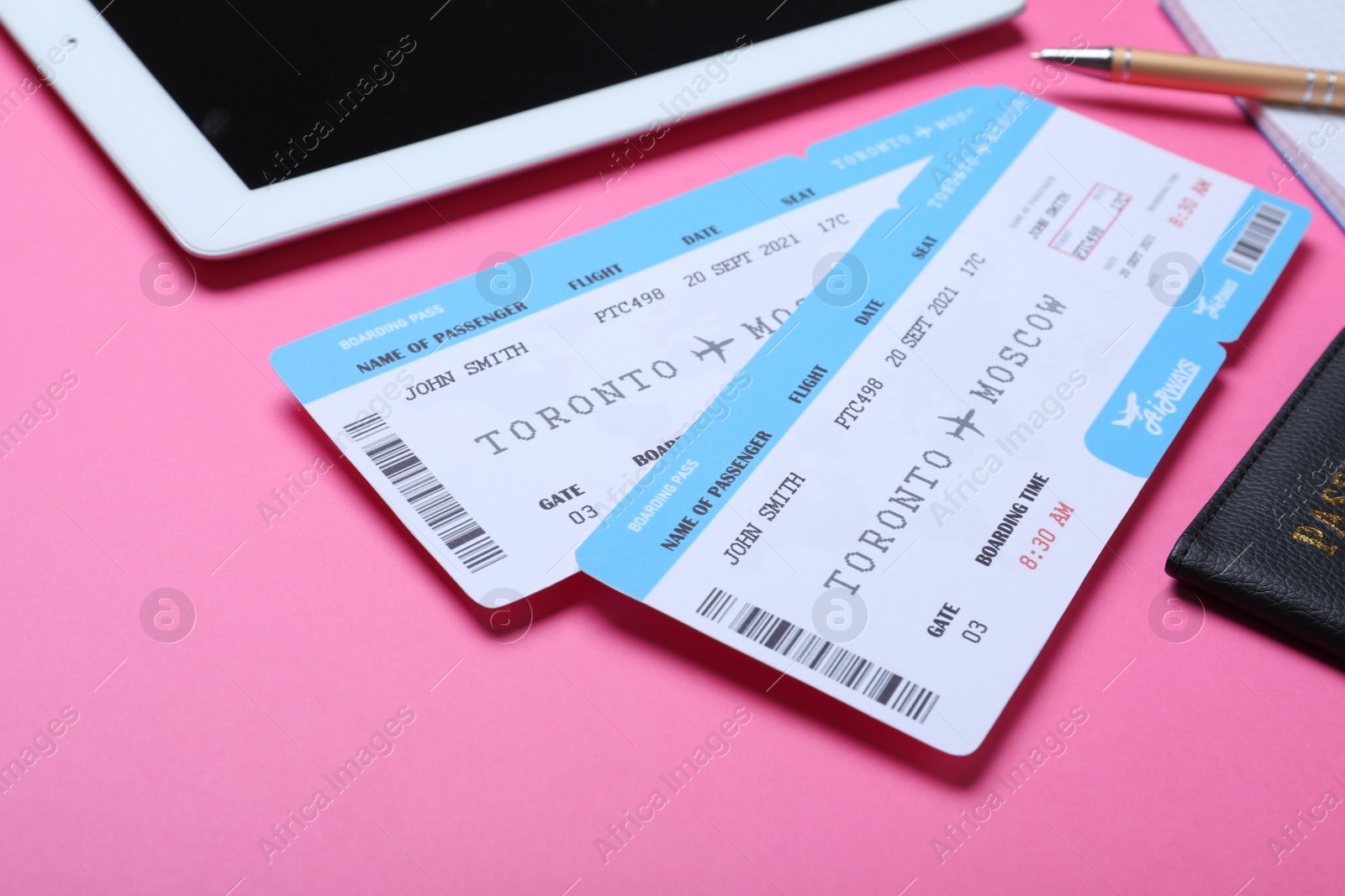 Photo of Tickets, passport and tablet on pink background. Travel agency concept