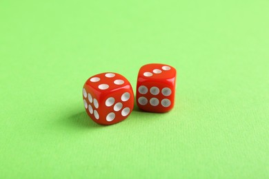 Photo of Two red game dices on green background, closeup