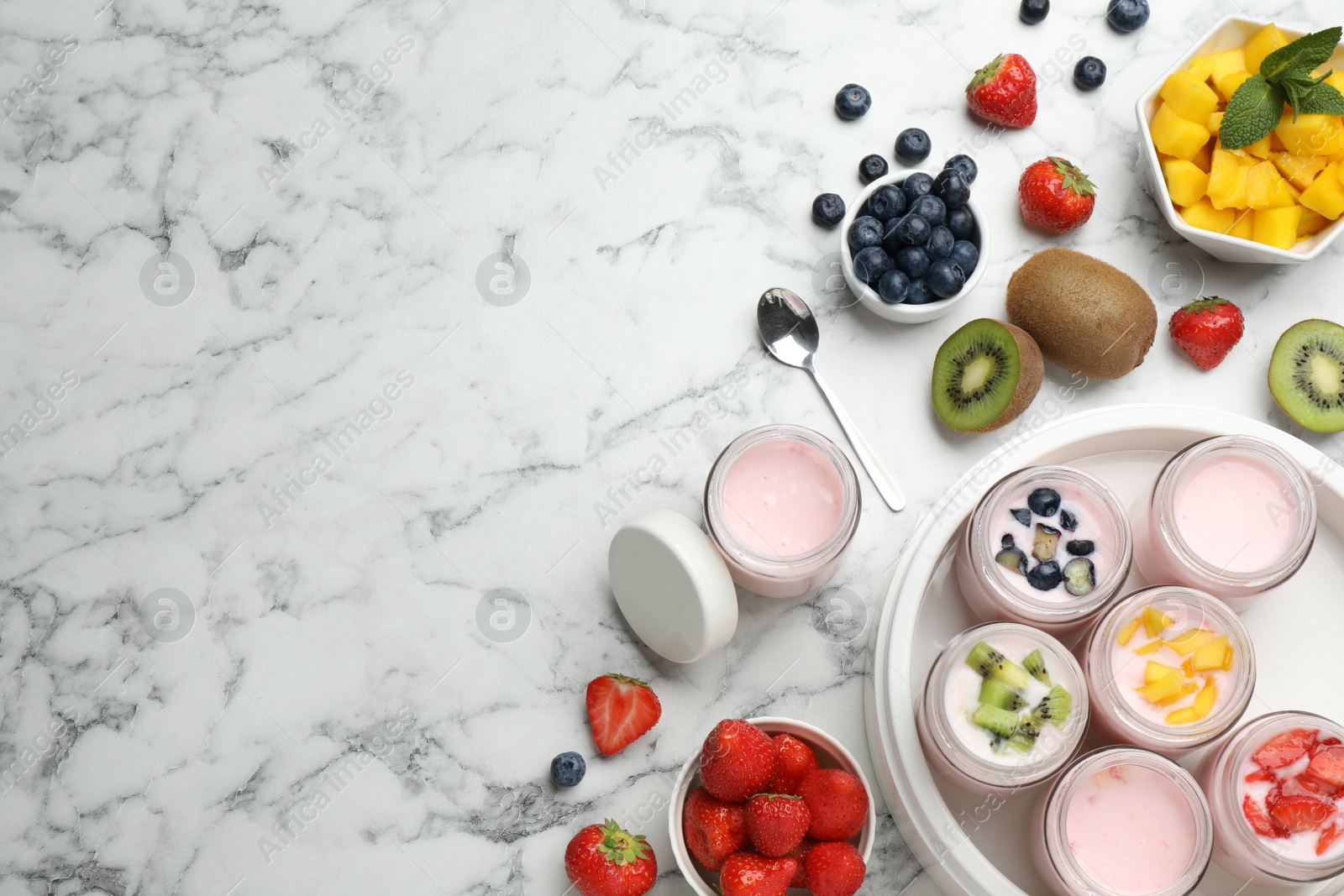 Photo of Modern yogurt maker with full jars and different fruits on white marble table, flat lay. Space for text