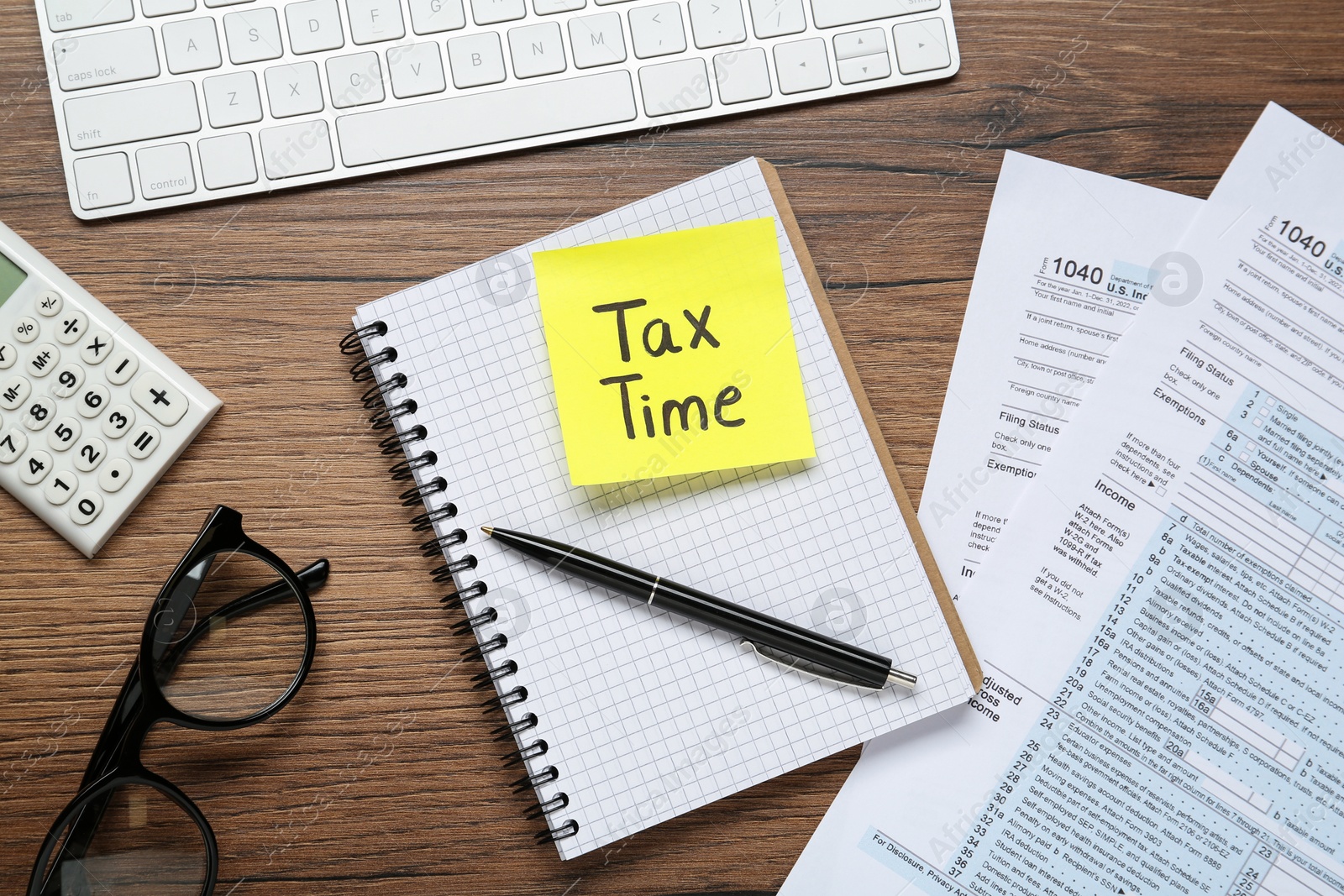 Photo of Reminder note with words Tax Time, documents, computer keyboard and calculator on wooden table, flat lay