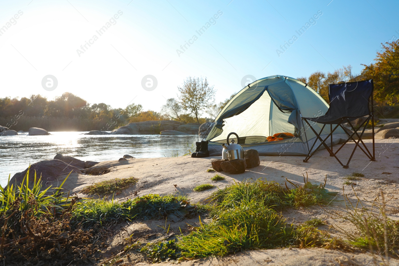 Photo of Camping equipment near tent with sleeping bag outdoors