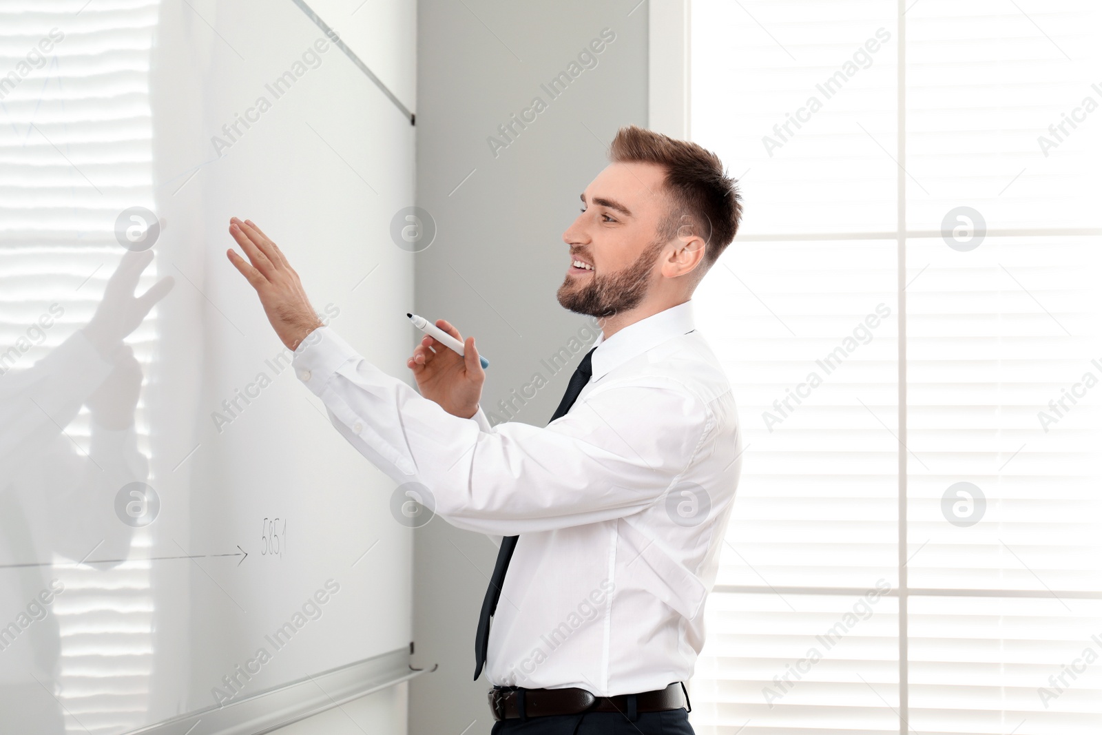 Photo of Professional business trainer near whiteboard in office