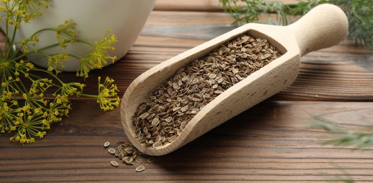 Image of Dill seeds in scoop on wooden table, closeup. Banner design