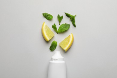 Photo of Blank tube of toothpaste with mint and lemon on white background, flat lay