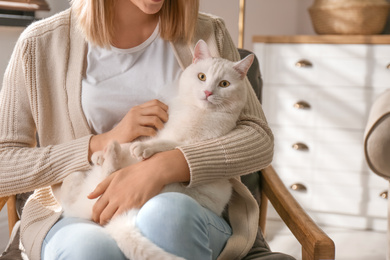 Photo of Young woman with her beautiful white cat at home, closeup. Fluffy pet