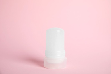Natural crystal alum stick deodorant on pink background