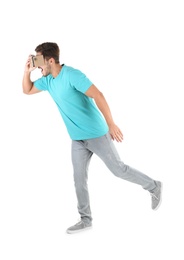 Young man using cardboard virtual reality headset, isolated on white