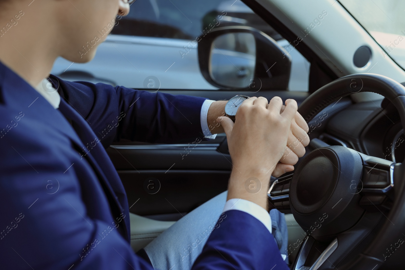 Photo of Man checking time in car, closeup. Being late