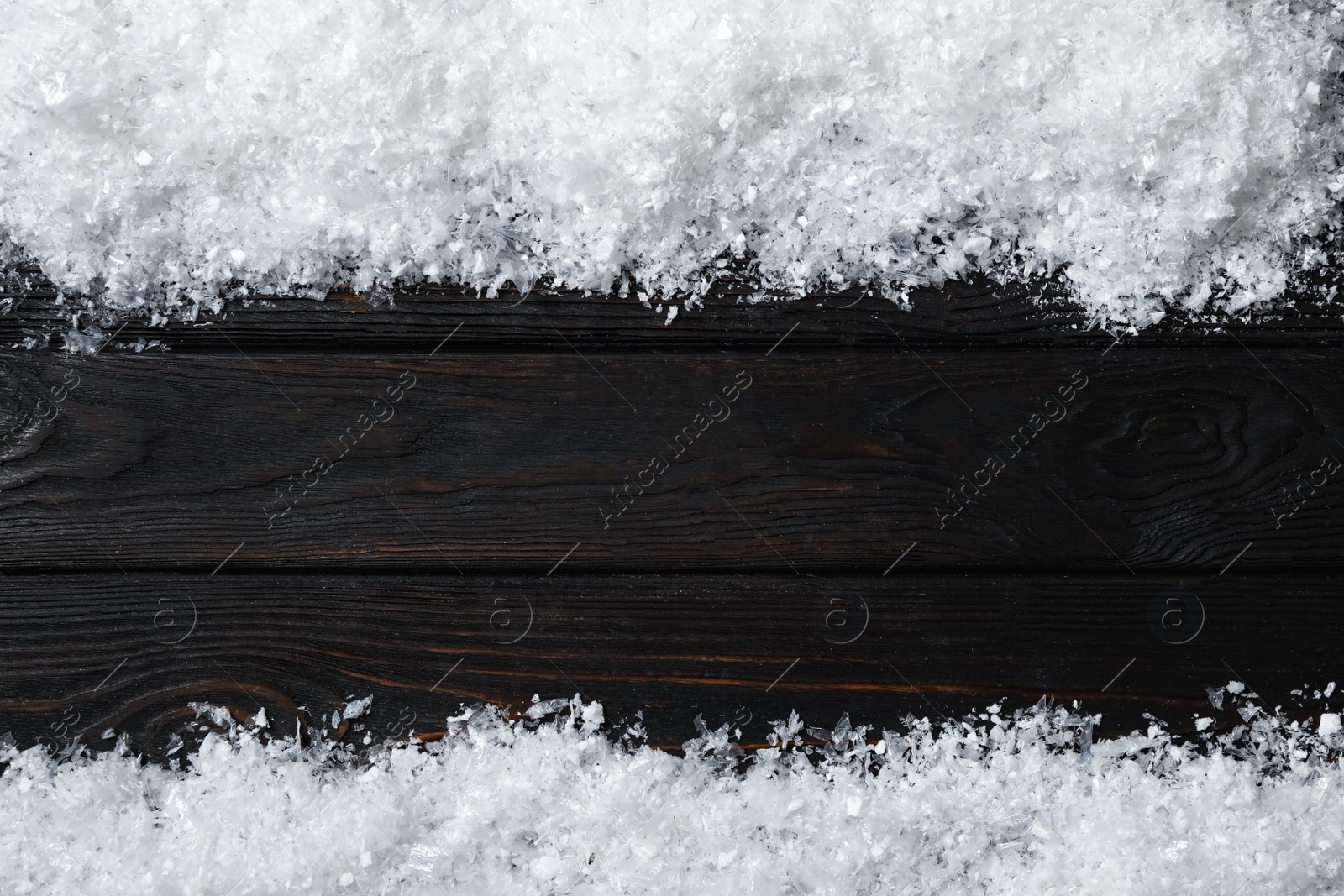 Photo of Frame made of snow on wooden background, top view with space for text. Christmas time