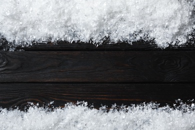 Frame made of snow on wooden background, top view with space for text. Christmas time