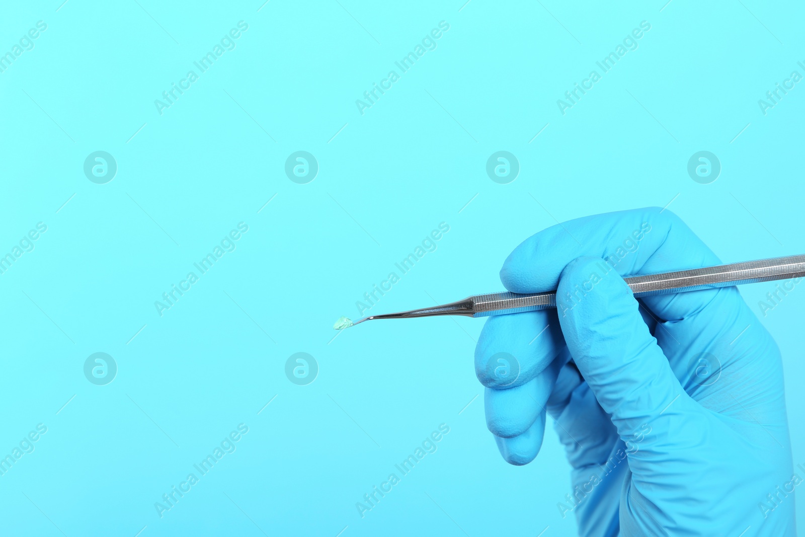 Photo of Dentist holding professional instrument on color background, space for text. Mouth and teeth care