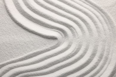 Photo of Pattern drawn on white sand, above view. Zen garden