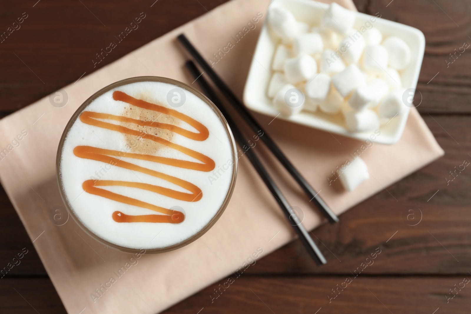 Photo of Glass with delicious caramel latte on table