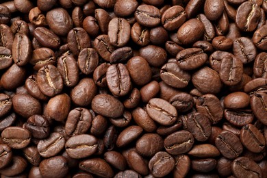 Pile of roasted coffee beans as background, top view