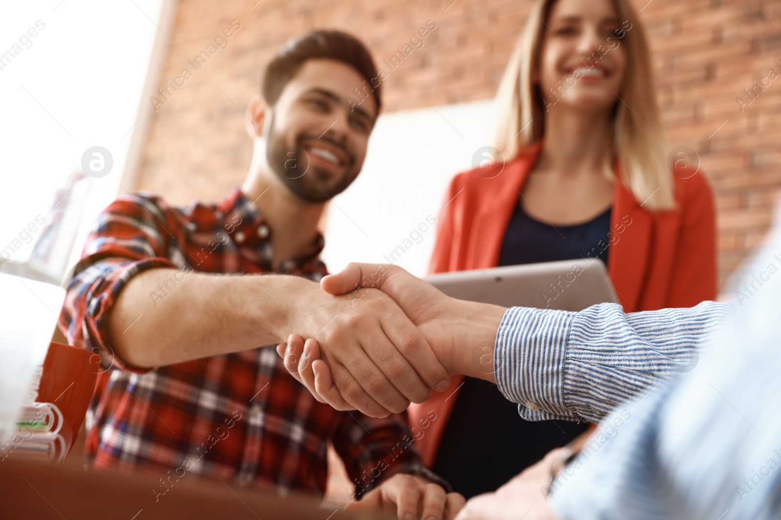 Photo of Business partners shaking hands after meeting, closeup