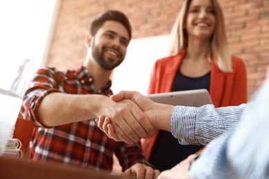 Photo of Business partners shaking hands after meeting, closeup