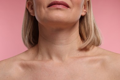 Woman with healthy skin on pink background, closeup