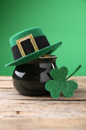 St. Patrick's day. Pot of gold with leprechaun hat and decorative clover leaf on wooden table