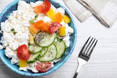 Photo of Delicious cottage cheese with vegetables and chia seeds served for breakfast on white wooden table, flat lay