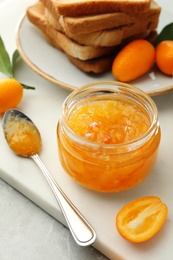 Delicious kumquat jam, fresh fruits and bread on white board