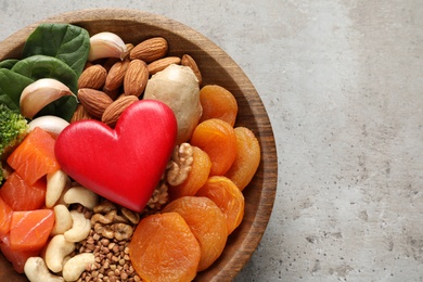 Photo of Bowl with heart-healthy products on grey background, top view. Space for text