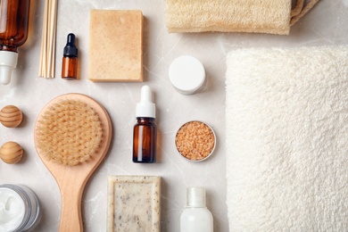 Photo of Flat lay composition with spa cosmetics and towel on light background
