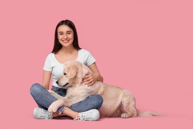 Photo of Happy woman with cute Labrador Retriever dog on pink background, space for text. Adorable pet