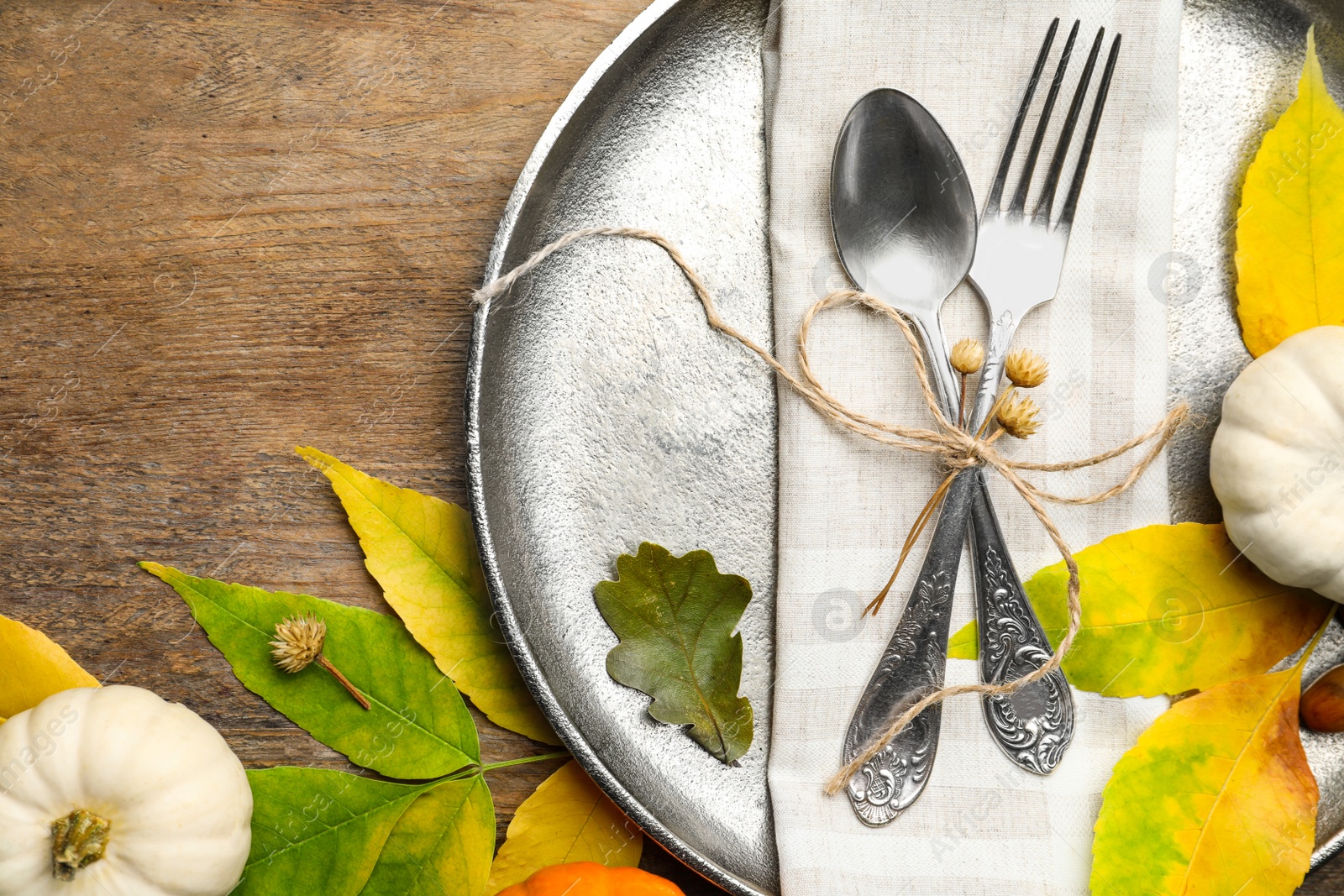 Photo of Seasonal table setting with pumpkins and other autumn decor on wooden background, flat lay