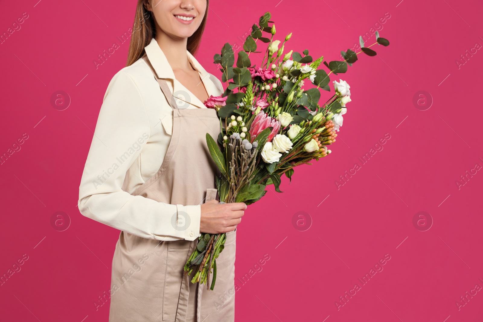 Photo of Florist with beautiful bouquet on pink background, closeup