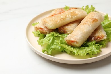 Photo of Delicious fried spring rolls on white table, closeup