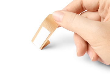 Photo of Woman putting sticking plaster on white background. First aid item