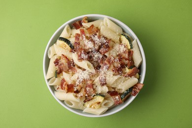 Photo of Tasty pasta with bacon and cheese on light green table, top view