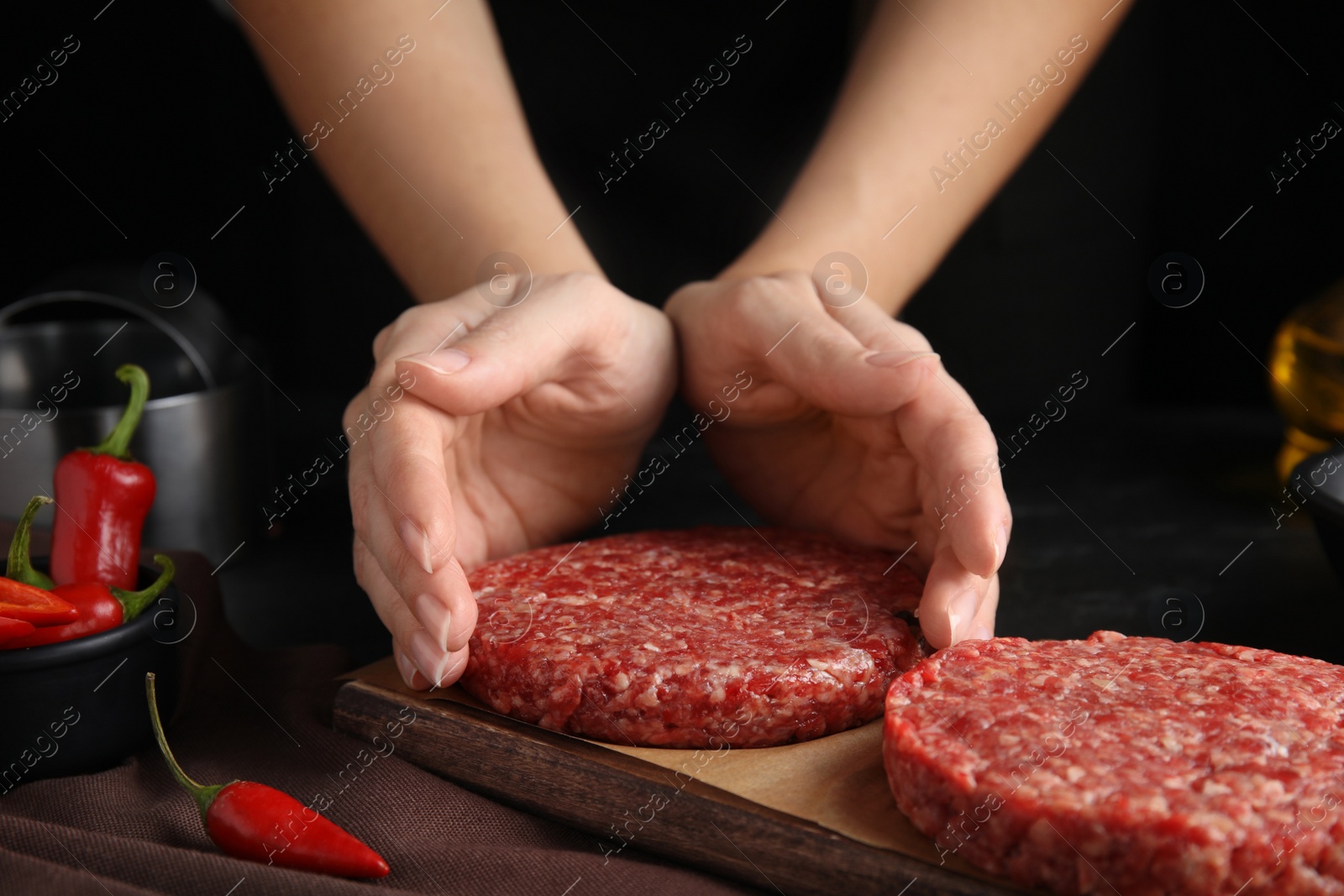 Photo of Woman making hamburger patties at wooden table, closeup