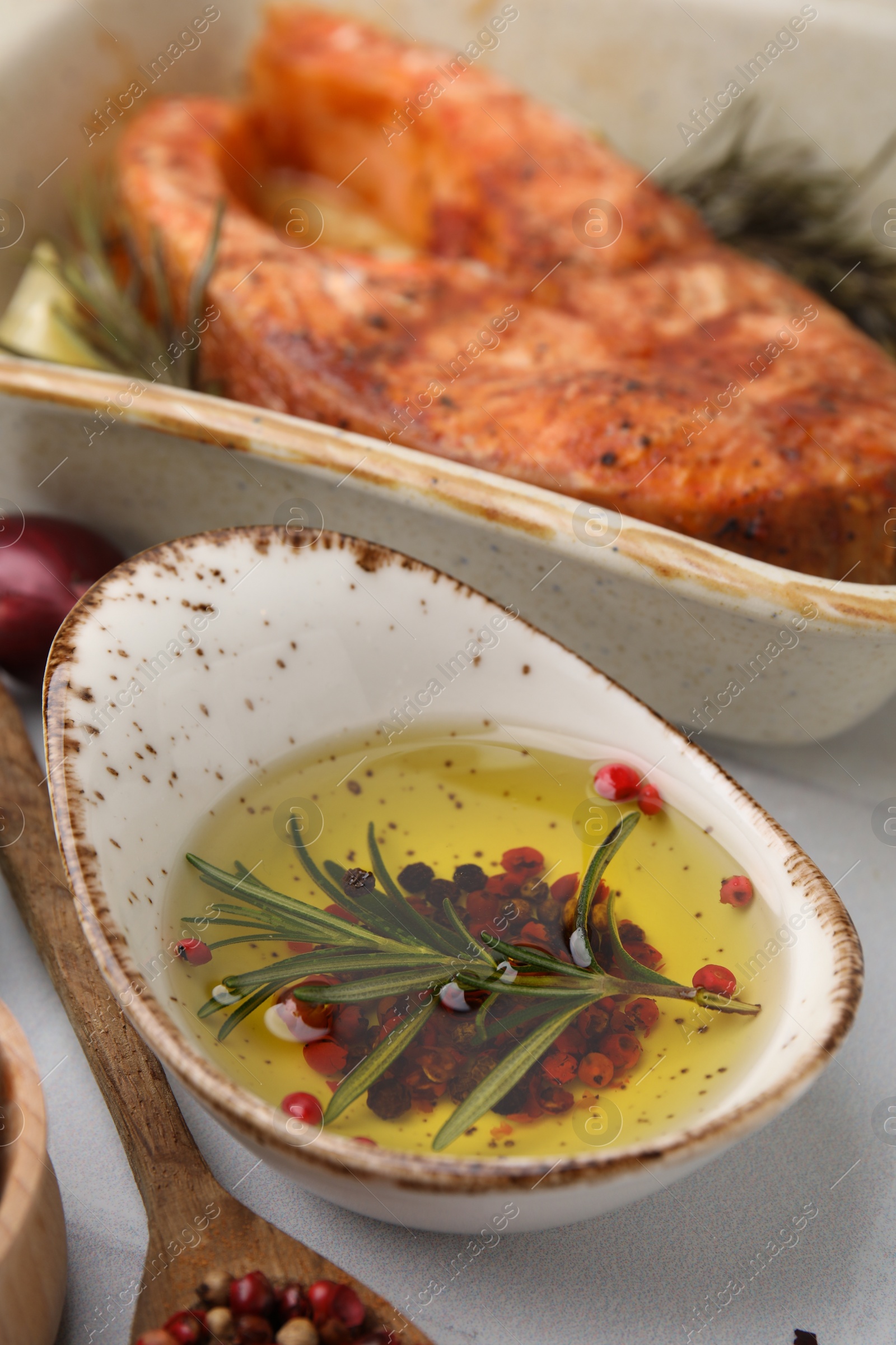 Photo of Fresh marinade and cooked fish on white tiled table, closeup