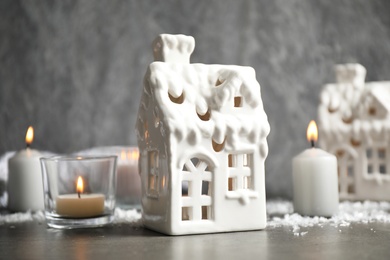Photo of Composition with house shaped candle holders on grey stone table. Christmas decoration