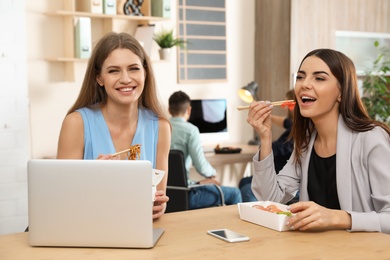 Photo of Office employees having lunch at workplace. Food delivery