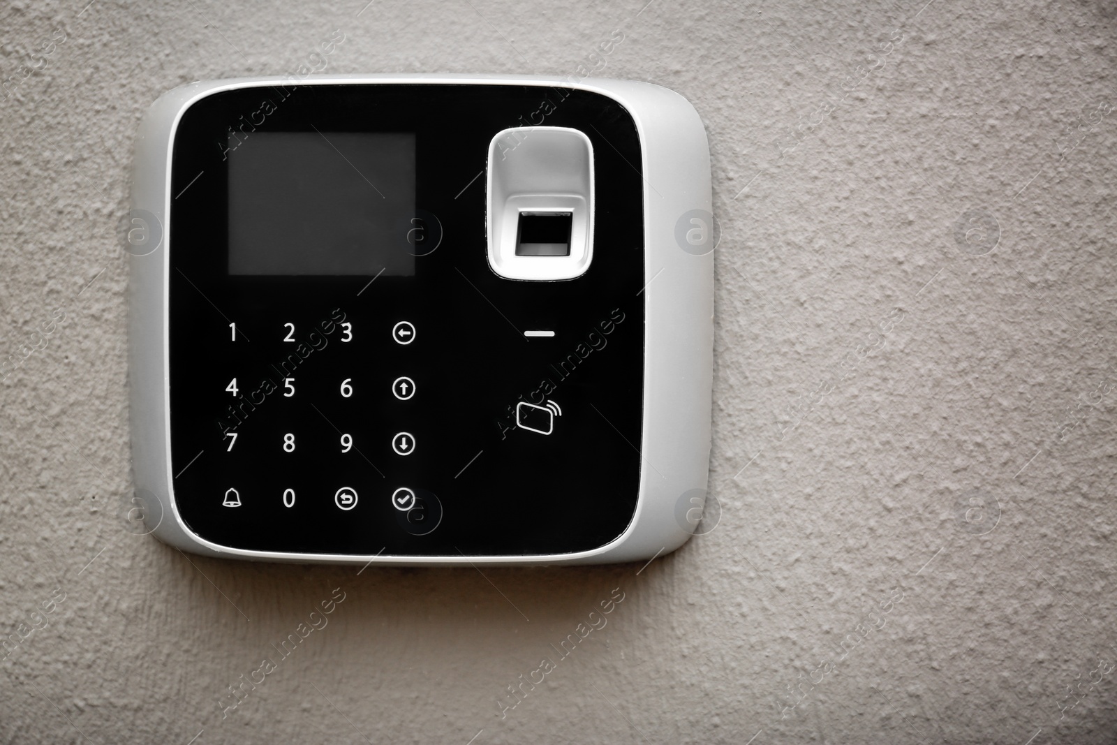 Photo of Modern alarm system with fingerprint scanner on light wall. Space for text