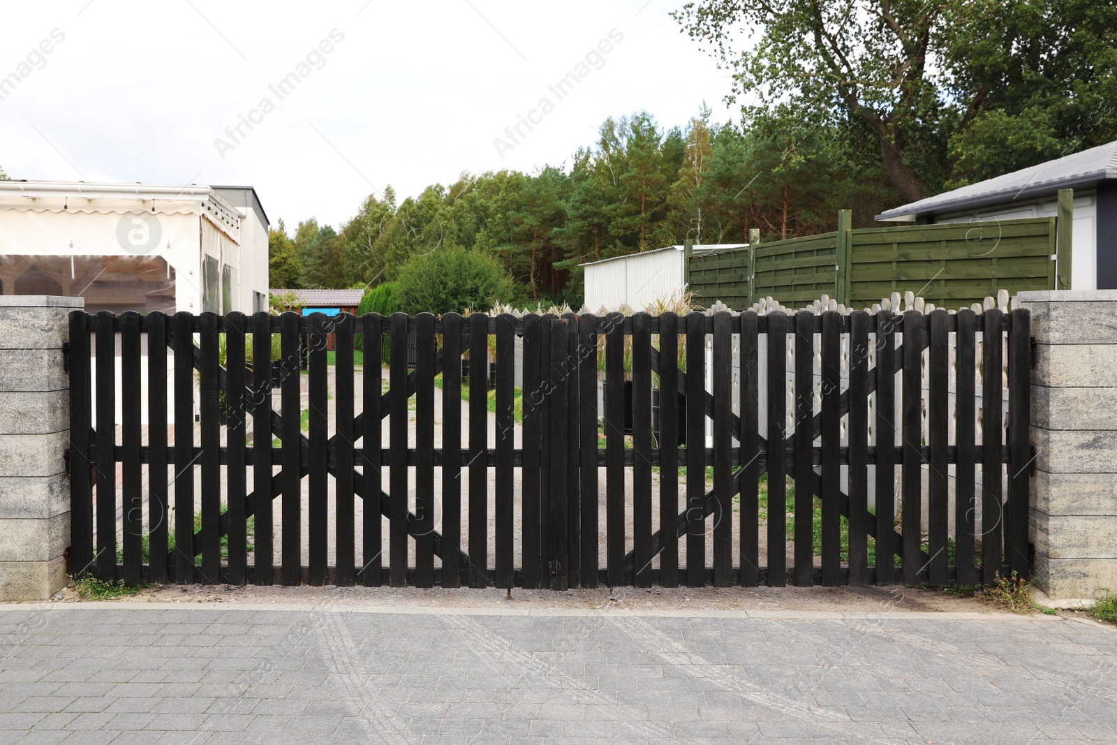 Photo of Closed wooden gates near beautiful trees and buildings outdoors