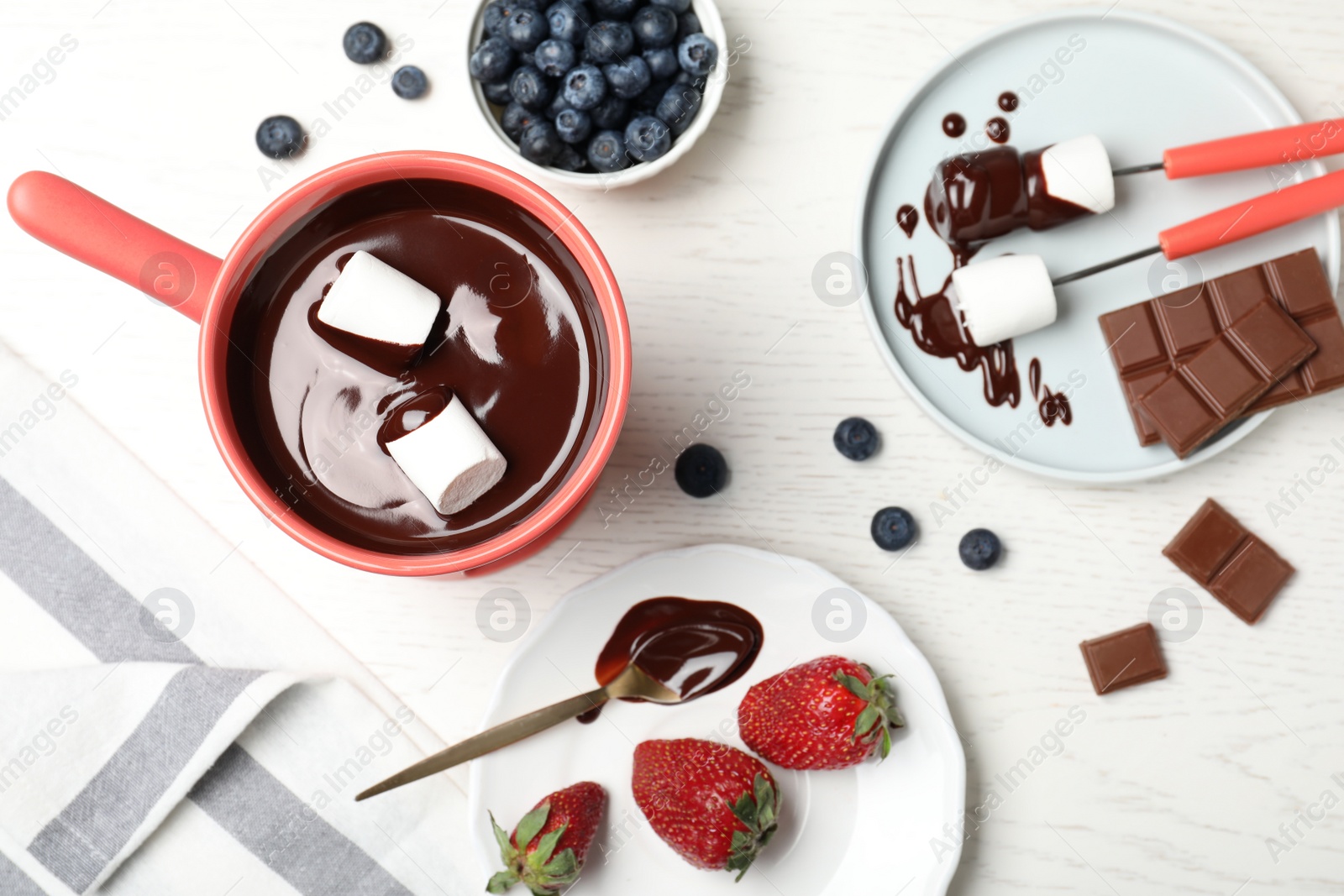 Photo of Chocolate fondue with strawberries and marshmallow on wooden table, flat lay