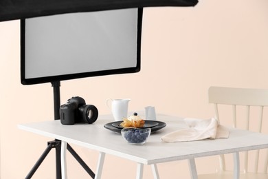 Photo of Professional equipment and composition with delicious dessert on white wooden table in studio. Food photography