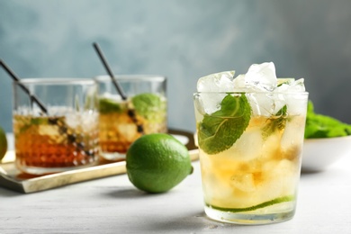 Glass of delicious mint julep cocktail on table