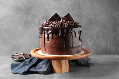 Photo of Freshly made delicious chocolate cake on grey table